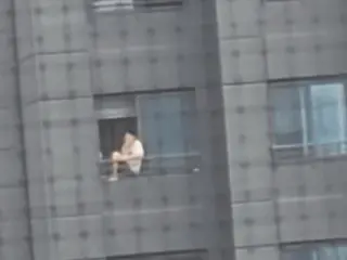 韓國一名男子坐在20層公寓樓欄桿抽菸引發爭議