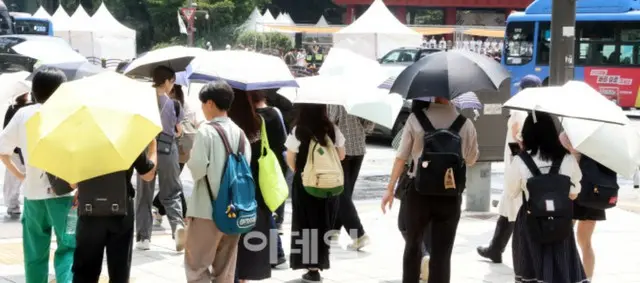 韓国全土で連日猛暑が続いた8月、市民が日傘をさして歩く様子