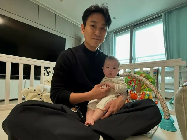 演員朱智勳微笑著抱著好友張水源（SECHSKIES）的女兒